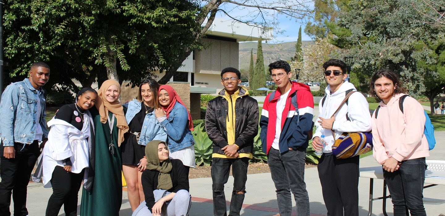 Students from campus clubs pose for a picture along Raider Walk.